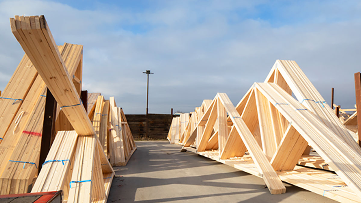 Engineered wood roof trusses with heavy galvanized connector plates bundled for Georgia jobsite delivery.