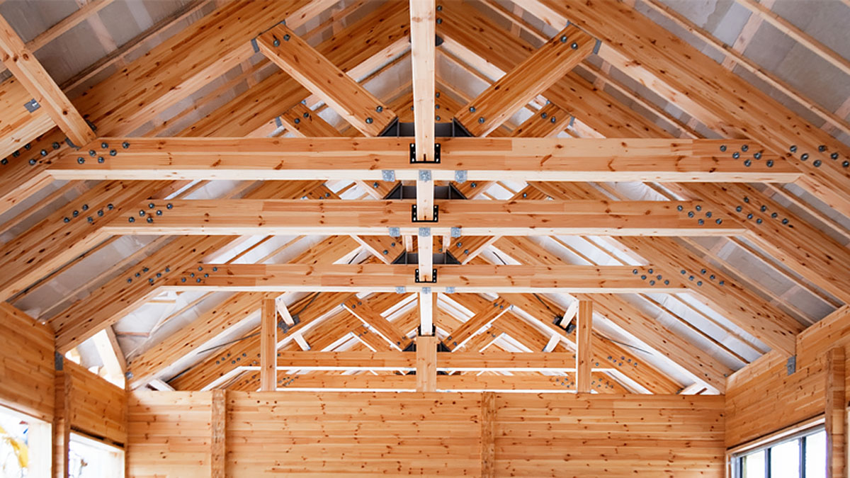 Engineered wood roof trusses with heavy galvanized connector plates bundled for Mississippi jobsite delivery.
