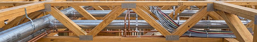 Installed open-web timber floor trusses on an elevated coastal stilt framing jobsite in Port Aransas, Texas.