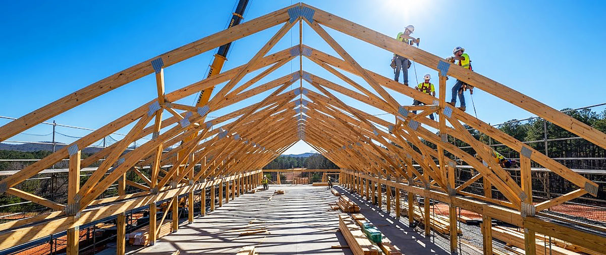 Clear-span Southern Yellow Pine engineered roof trusses framed on a commercial jobsite in Alabama.