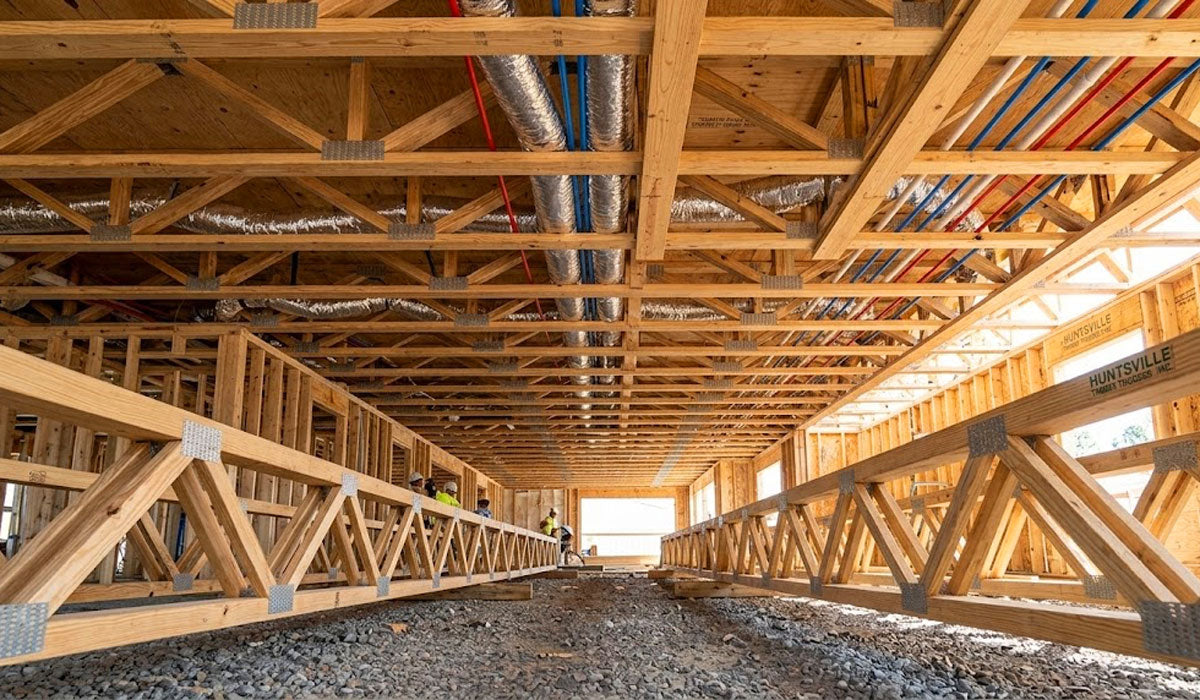 Open-web timber floor trusses installed on a multi-family framing site in Walker County, Huntsville, Texas.