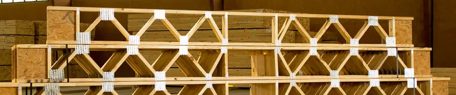 Open-web timber floor trusses installed on a commercial construction framing site in Lufkin, Texas.