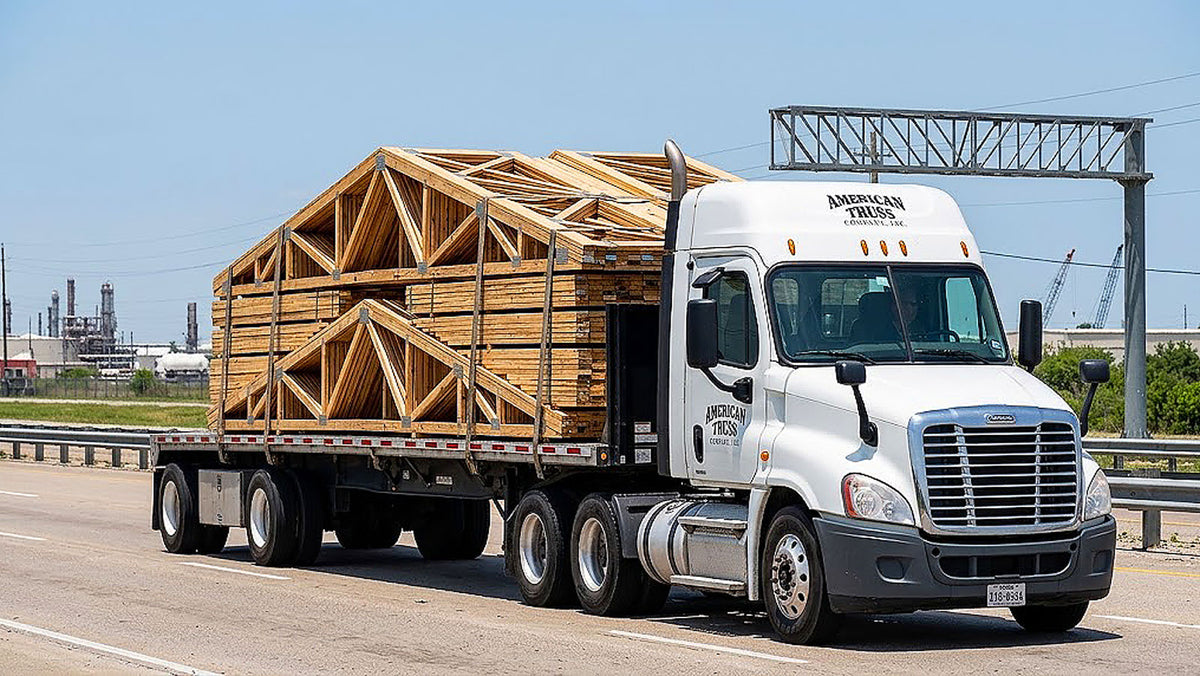 American Truss commercial flatbed truck transporting banded timber roof trusses along TX-73 near Port Arthur, Texas.