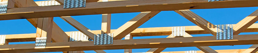 Open-web timber floor trusses installed on a commercial construction framing site in Port Arthur, Texas.